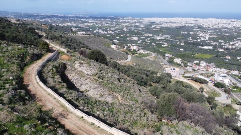 Vertical aerial shot of building plot with expansive sea and valley views