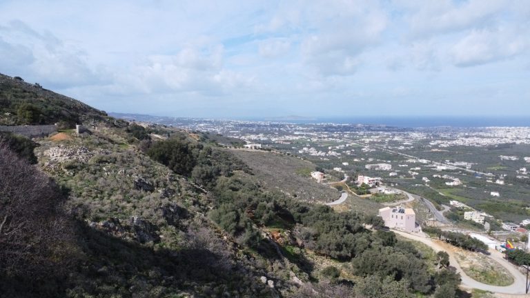 Aerial side view of residential plot in Malaxa overlooking Chania and Souda Bay
