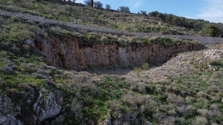 Drone aerial view of land plot for sale in Malaxa, Crete with mountain and countryside landscape