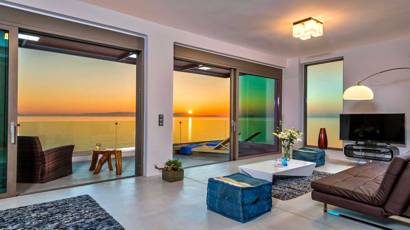 Luxury villa living room with panoramic sea view at sunset in Crete