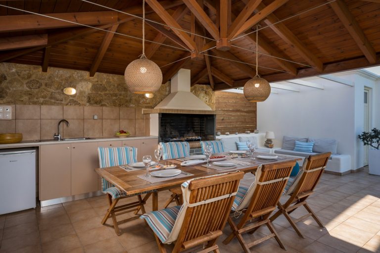 Luxury property in Afrata Crete featuring outdoor pergola dining area and built-in stone BBQ