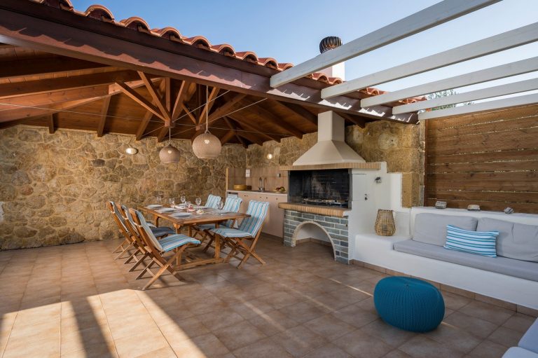 Luxury Afrata property exterior with pool, patio pergola, outdoor dining and stone barbecue area