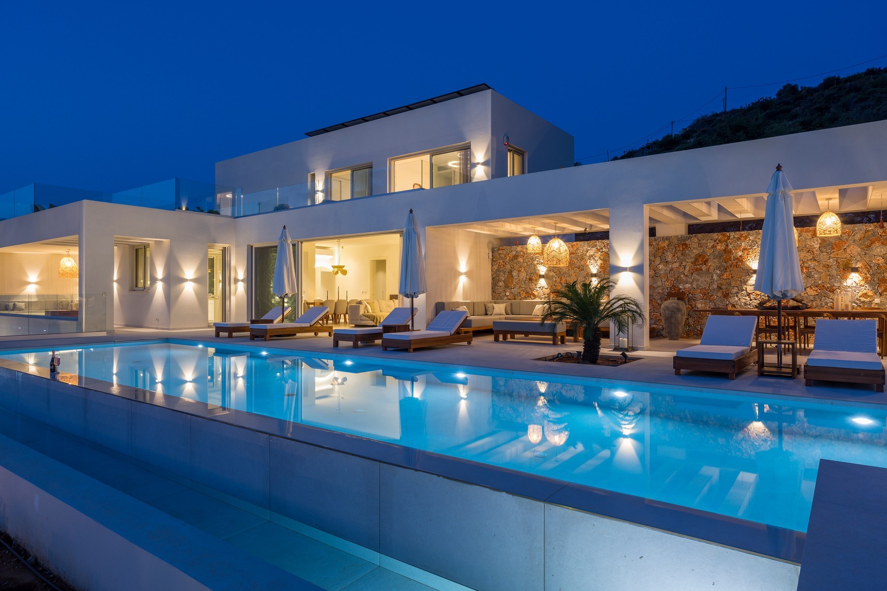 Luxury villa illuminated at night representing professional villa rental management services in Crete
