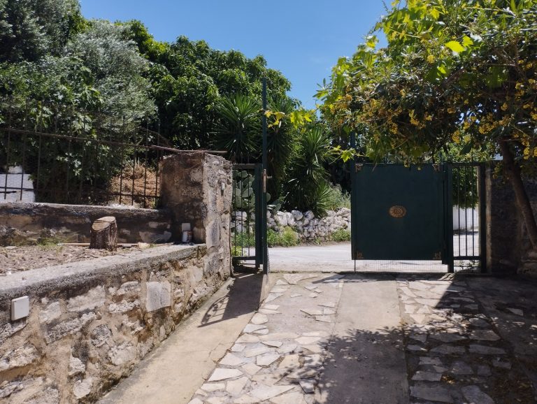 courtyard of property for sale in apokoronas with trees and garden and gate door